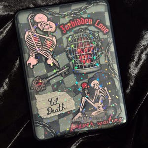 Op de afbeelding: Een telefoonhoesje met een donkergrijs en zwart geblokt patroon. De hoes heeft skeletillustraties, de woorden "Forbidden Love", "'til Death" en "forever waiting". Het ontwerp bevat een sleutel, een hart in een kooi en kettingdetails.