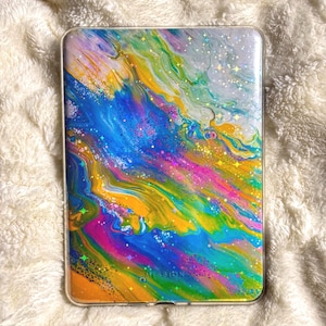 May include: A rectangular case with a colourful, abstract design. The case features a swirling pattern of blue, yellow, pink, and green hues, with sparkling accents. The word "MISSION" is visible on the bottom of the case.