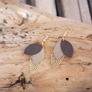 May include: A pair of gold tone earrings with brown and beige leather leaf shapes and a gold wire mesh design.