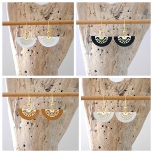 May include: Four pairs of gold earrings with a half-circle design. The earrings are made of leather and have a gold-colored metal hook. The leather is white, black, brown, and tan.