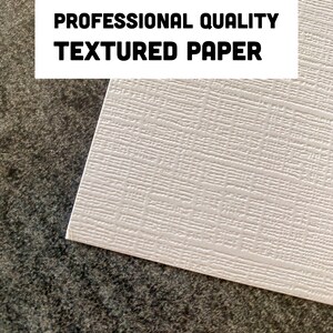 May include: Close-up of a white textured paper with the text "PROFESSIONAL QUALITY TEXTURED PAPER" printed in black.