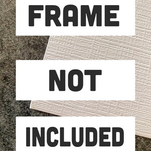 May include: White rectangular sign with black text that reads "FRAME NOT INCLUDED".