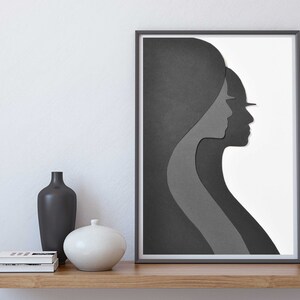 May include: A framed black and white abstract art print featuring two overlapping silhouettes of faces in profile. The print is on a white background and is framed in a black frame.