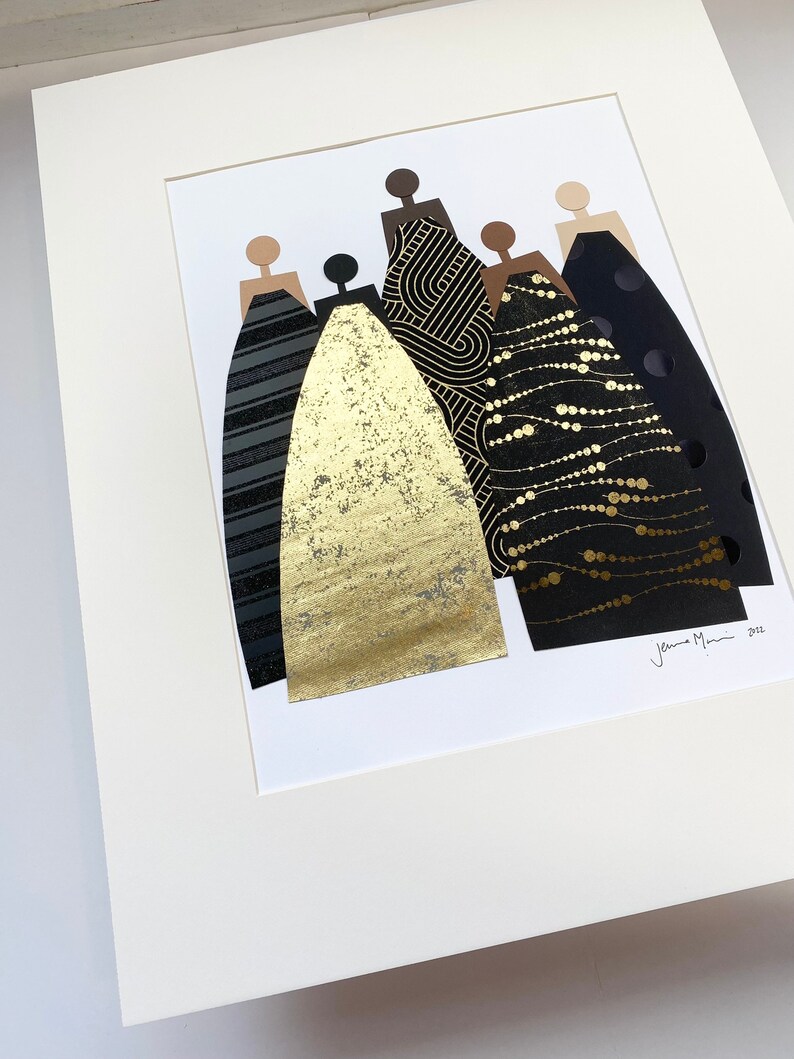 May include: A framed collage of five figures in black and gold dresses. The dresses are made of different patterned papers, including geometric, polka dot, and a gold foil. The artwork is signed "Jenna Mani 2022".