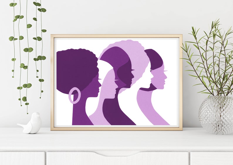Peut inclure: Une impression d'art encadr&eacute;e repr&eacute;sentant des profils de cinq femmes dans des tons de violet et de blanc. L'&oelig;uvre pr&eacute;sente diverses coiffures et silhouettes, cr&eacute;ant un sentiment d'unit&eacute; et de force. L'impression est affich&eacute;e sur une surface blanche.