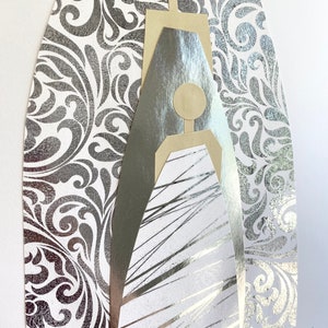 May include: A silver and gold abstract art piece with a geometric design. The piece is set against a silver damask background. The artist's signature, "Jana Mani 2022", is in the bottom right corner.