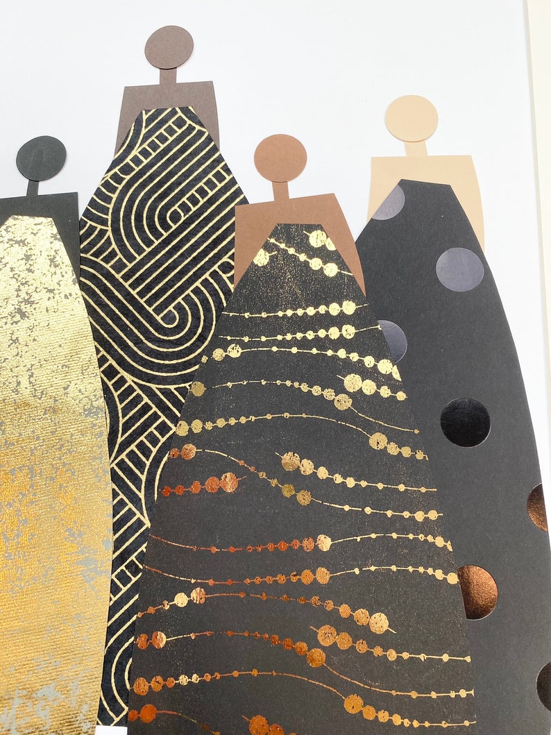 May include: Five paper cutouts of figures in black dresses with gold and copper accents. The dresses have different patterns, including geometric shapes, polka dots, and a beaded design.