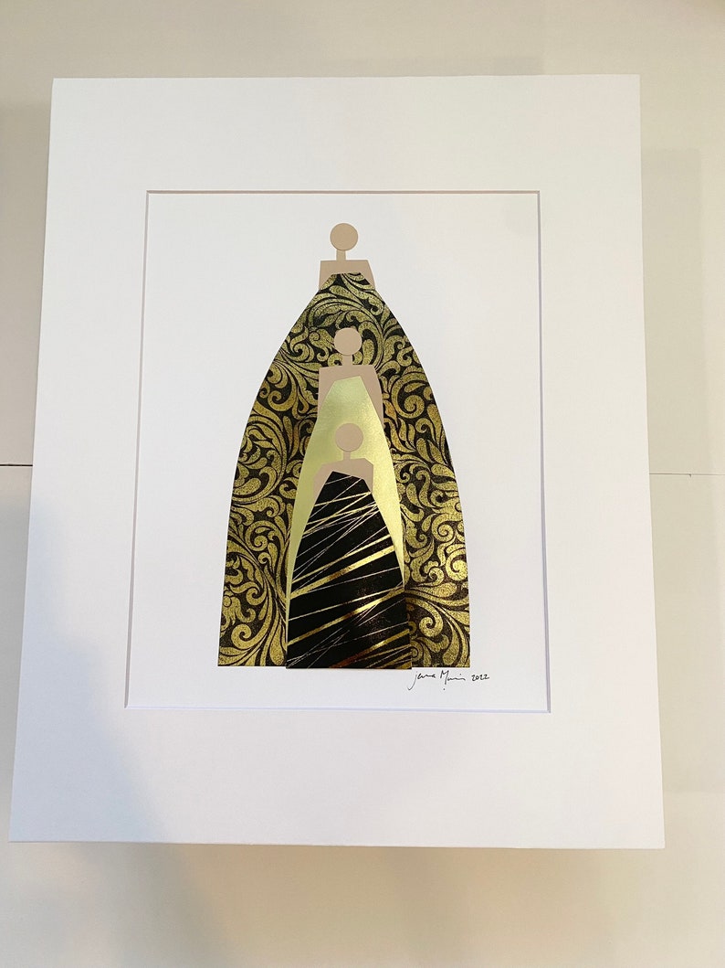 Pu&ograve; includere: Una stampa d'arte incorniciata che presenta un design astratto in oro e nero di tre figure. Le figure sono sovrapposte, con la figura pi&ugrave; grande in basso e la figura pi&ugrave; piccola in alto. Il design ricorda un ritratto di famiglia.