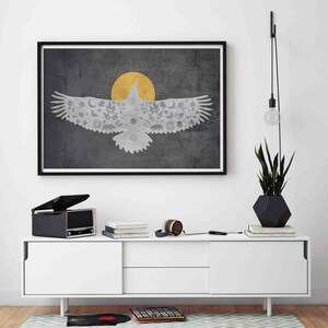 May include: A framed print of a stylized eagle with a sun and floral patterns in the background. The eagle is white and the background is gray with a gold sun.