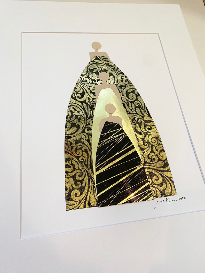 Pu&ograve; includere: Un collage incorniciato di tre figure in oro e nero, con un motivo a spirale sui bordi esterni. Le figure sono sovrapposte, con la figura pi&ugrave; grande sul retro e la figura pi&ugrave; piccola sul davanti. La firma dell'artista, "Jena Mann 2012", &egrave; nell'angolo in basso a destra.
