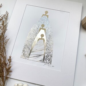 May include: A white matted print with a gold silhouette of three figures standing on top of each other. The figures are surrounded by a silver patterned background. The print is signed "Jenna Mani 2022" in the bottom right corner.