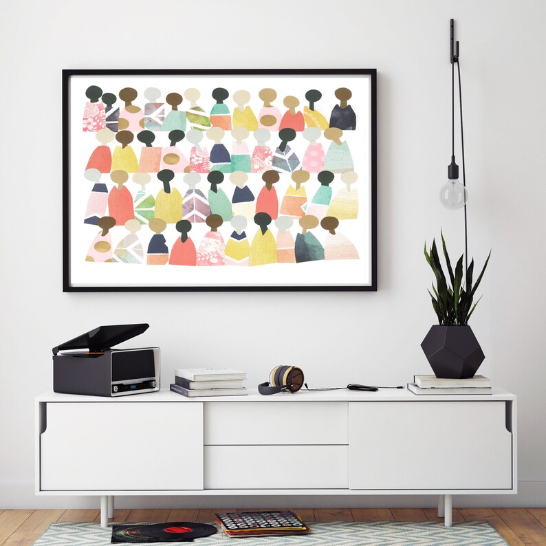 May include: A black framed print of a colorful abstract art piece featuring a group of people in various shades of pink, blue, green, yellow, and orange. The print is hanging on a white wall above a white dresser.