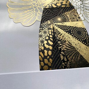 May include: An abstract art print in black and gold, depicting a stylised figure with wings. The figure is composed of geometric shapes and patterns, including circles, stars, and animal print.