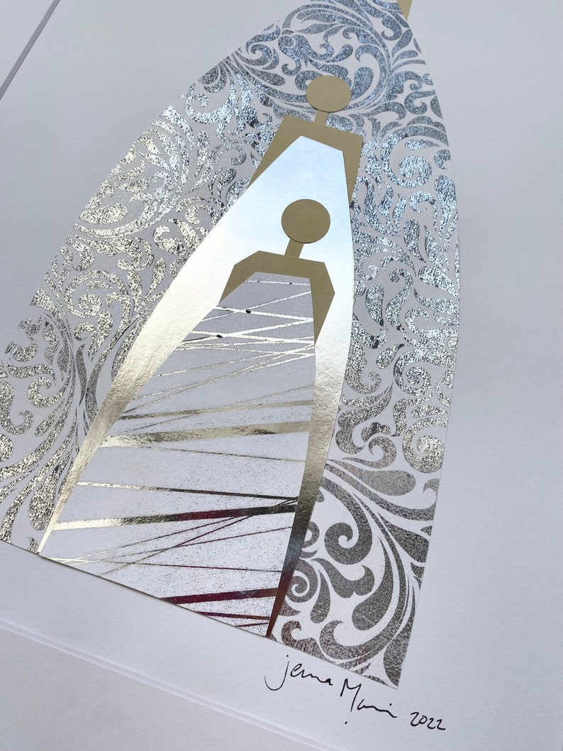 May include: A silver and gold abstract art print with a stylized image of two figures. The print has a silver background with a gold floral pattern. The artist's signature "Jena Mani 2022" is in the bottom right corner.