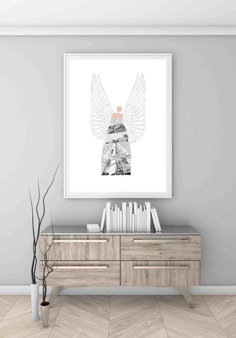 May include: A black and white illustration of an angel with wings. The angel is wearing a dress made of different patterns. The illustration is framed and hanging on a wall above a wooden dresser.
