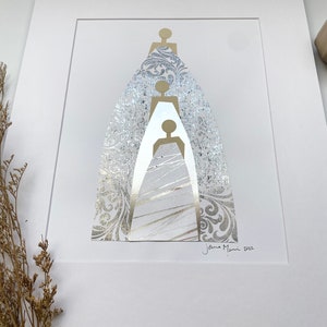 May include: A white matted print with a gold and silver abstract design of three figures. The figures are layered on top of each other and are surrounded by a silver patterned background. The print is signed "Jenna Mani 2022" in the bottom right corner.