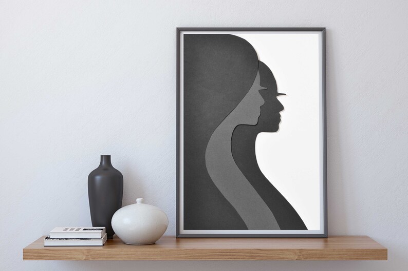 May include: A framed black and white abstract art print featuring two overlapping silhouettes of faces in profile. The print is on a white background and is framed in a black frame.