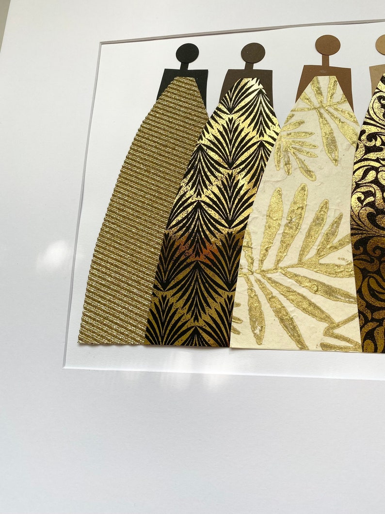 May include: Five abstract figures in a row, each with a different gold patterned dress. The figures are cut out of paper and mounted on a white background.
