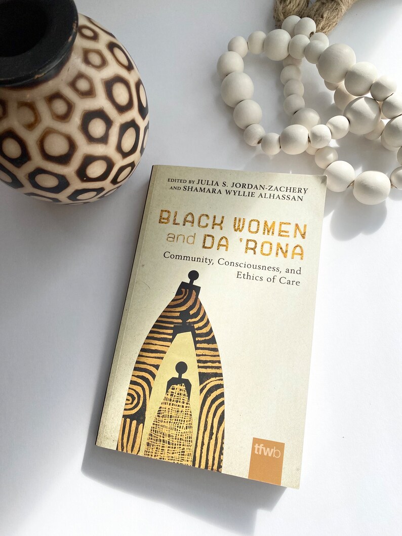 Pu&ograve; includere: Un libro intitolato "Black Women and Da 'Rona: Community, Consciousness, and Ethics of Care" di Julia S. Jordan-Zachery e Shamara Wyllie Alhassan. La copertina presenta un'illustrazione stilizzata di due figure in una porta.