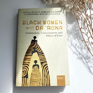 K&ouml;nnte beinhalten: Ein Buch mit dem Titel "Black Women and Da 'Rona: Community, Consciousness, and Ethics of Care" mit einer goldenen und schwarzen Illustration auf dem Cover.
