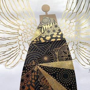 May include: A gold and black angel with wings made of paper. The angel's body is made of a variety of patterned papers, including geometric patterns, animal prints, and floral designs.