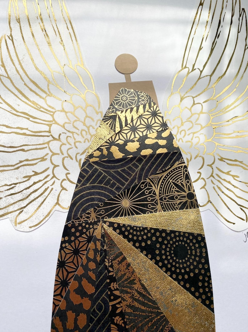 May include: A gold and black angel with wings made of paper. The angel's body is made of a variety of patterned papers, including geometric patterns, animal prints, and floral designs.