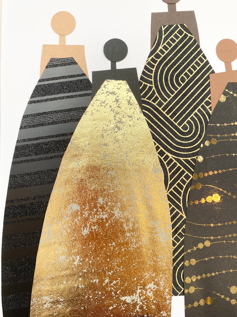 May include: Five paper figures stand in a row, each wearing a different patterned dress. The dresses are black and gold with geometric and abstract designs.