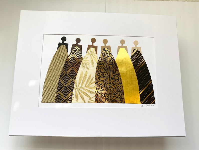 May include: A framed collage of seven figures in black silhouettes wearing gold and black patterned dresses. The dresses are made of different materials, including textured paper, metallic foil, and fabric.