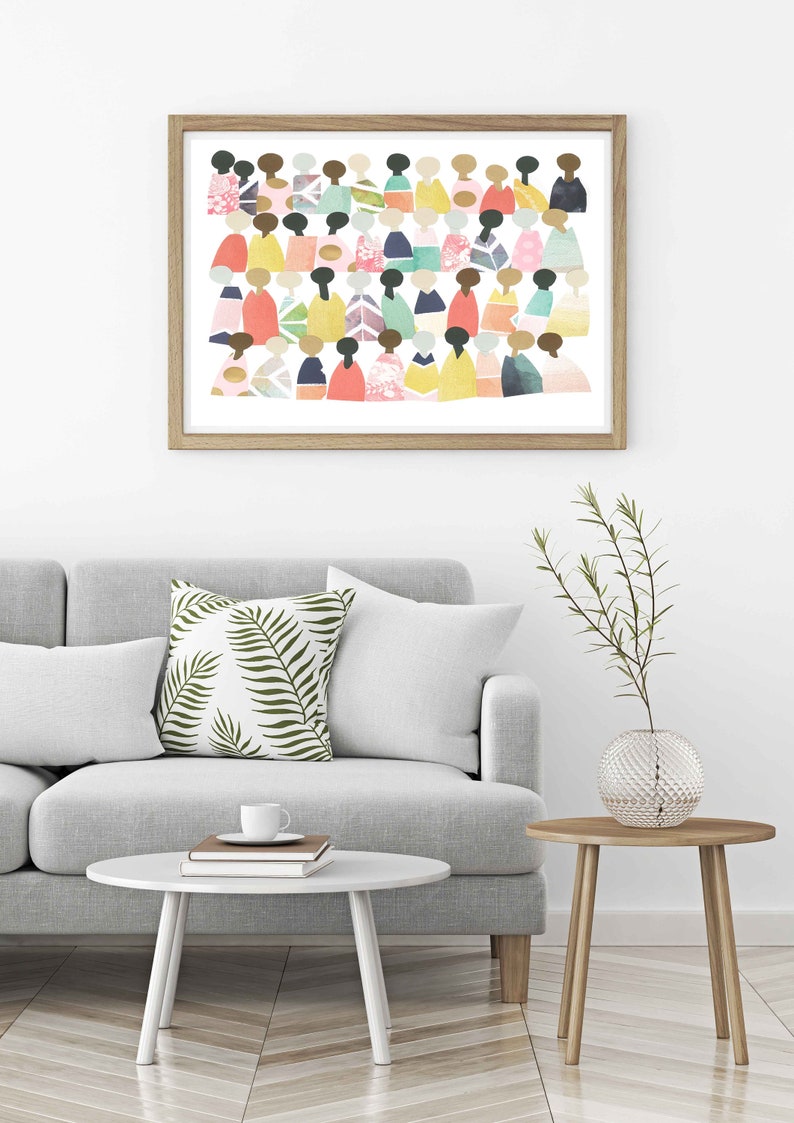May include: A framed print of a colorful abstract art piece featuring a crowd of people in various shades of pink, blue, green, yellow, and orange. The print is set against a white background and framed in a light wood frame.