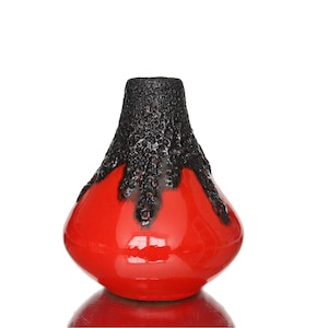 May include: A bulbous ceramic vase featuring a smooth, glossy red finish on the lower portion and a textured, matte black lava-style glaze dripping down from the narrow neck, creating a distinct contrast between the two colours and surface finishes.