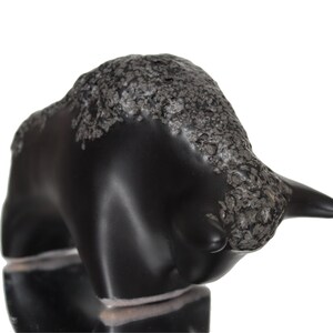May include: Black ceramic bull figurine with a textured silver finish. The bull is standing with its head lowered and horns pointed forward.