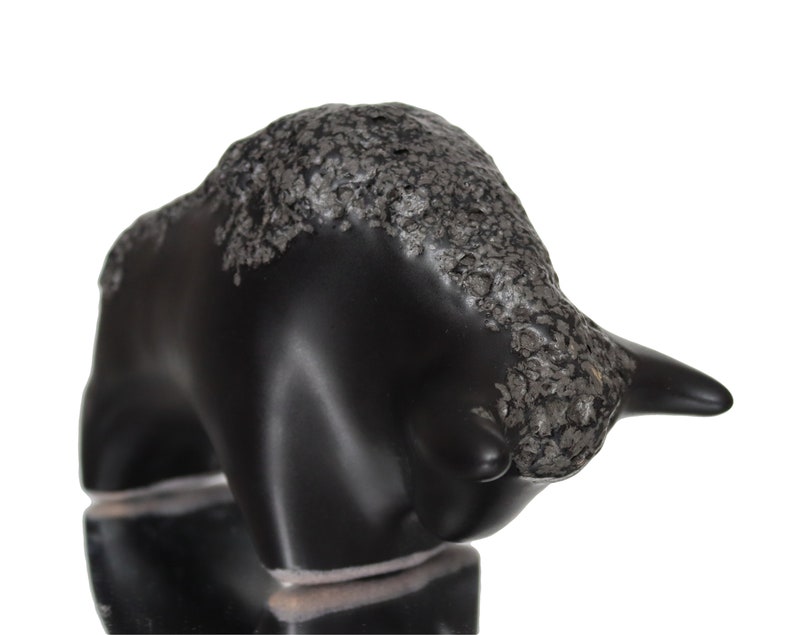 May include: Black ceramic bull figurine with a textured silver finish. The bull is standing with its head lowered and horns pointed forward.