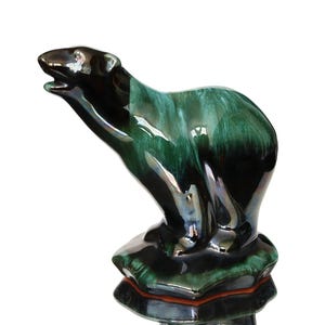 Può includere: Una statuetta di orso polare in ceramica con una glassa nera e verde. L'orso è in piedi su una base con una glassa verde e nera.