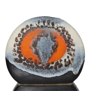 Könnte beinhalten: Eine Keramikvase mit einem abstrakten Design in Schwarz, Weiß, Orange und Braun. Die Vase hat eine abgerundete Form und einen kleinen Sockel.