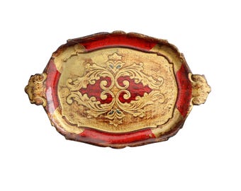May include: An oval-shaped wooden serving tray with a red and gold painted design. The tray has a raised edge and ornate details.