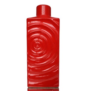 Könnte beinhalten: Eine rote Keramikvase mit einem wirbelnden Muster. Die Vase ist rechteckig und hat eine breite Öffnung.