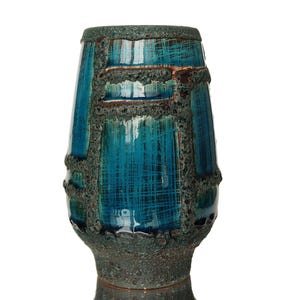 Könnte beinhalten: Eine türkisfarbene und braune Keramikvase mit strukturierter Oberfläche. Die Vase hat eine zylindrische Form, die oben breiter und unten schmaler ist. Das Türkis wird durch braune und dunkelgrüne Details akzentuiert.