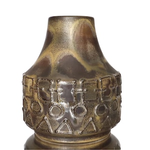 Op de afbeelding: Een vintage keramische vaas met een gestructureerd, geometrisch ontwerp. De vaas heeft een donkerbruin en goud kleurenschema met een glanzende afwerking. Het ontwerp omvat vierkanten, cirkels en driehoeken. De vaas heeft een brede basis en een smallere hals.