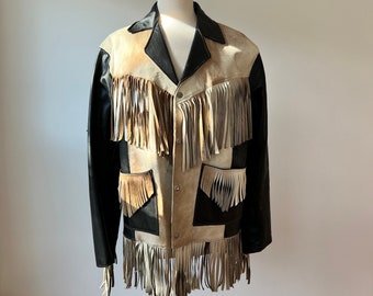 May include: A black and brown leather jacket with fringe detailing. The jacket has a snap closure and multiple pockets.