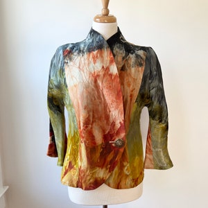 May include: A colorful, abstract patterned jacket with a button closure. The jacket is made of a soft, flowing fabric and has a relaxed fit.