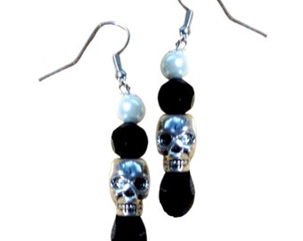 May include: Silver skull and black bead dangle earrings with a white pearl bead.