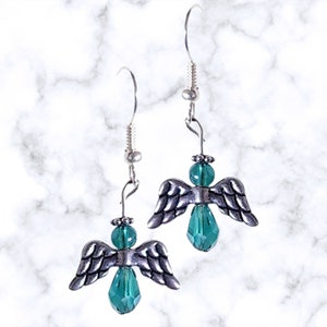 Pu&ograve; includere: Orecchini in argento con ali d'angelo e perline di cristallo verde a forma di lacrima.