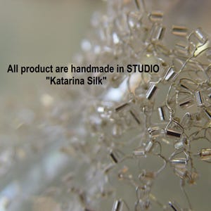 May include: Close-up of a silver beaded chain, with a blurred background. The text "All product are handmade in STUDIO "Katarina Silk"" is visible in the image.