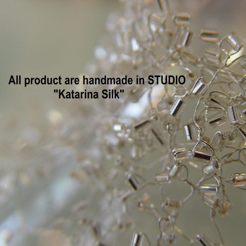 May include: Close-up of a silver beaded chain, with a blurred background. The text "All product are handmade in STUDIO "Katarina Silk"" is visible in the image.