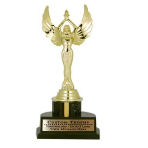 Peut inclure: Trophée doré avec une figure féminine ailée tenant une étoile. Le socle est noir avec une plaque dorée qui indique "Trophée personnalisé - Jusqu'à 3 lignes Votre message ici".