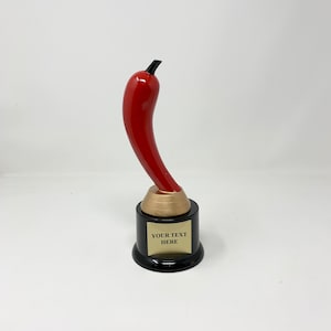 Può includere: Trofeo a forma di peperoncino rosso con base nera e una placca dorata con la scritta "YOUR TEXT HERE".