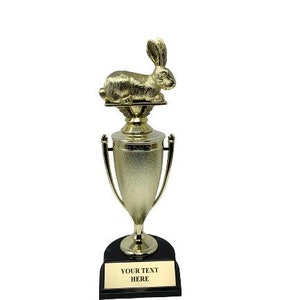 May include: Gold trophy with a rabbit figurine on top. The trophy has a black base with a gold plate that says "YOUR TEXT HERE".