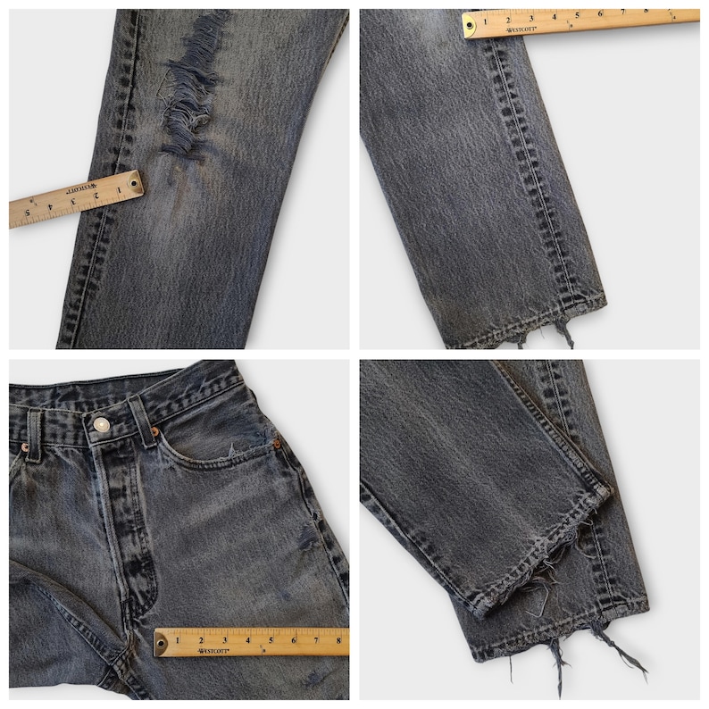May include: Close-up shots of distressed, faded black denim jeans. The jeans feature ripped details on the leg and a raw, frayed hem. A ruler is placed on the jeans to show measurements. The jeans have a button closure and classic five-pocket design.