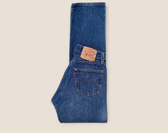Calça jeans vintage Levi's 501 com braguilha de botões, tamanho 27, azul escuro desbotado com efeito bigode.