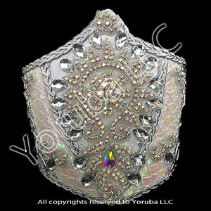 Puede incluir: Una corona blanca con un dise&ntilde;o de cuentas plateadas y diamantes de imitaci&oacute;n iridiscentes. La corona est&aacute; decorada con un gran patr&oacute;n floral adornado.